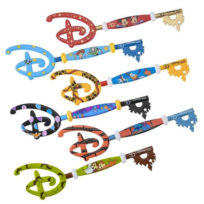 Seven Disney collectible keys with different character-themed designs arranged on a white background.