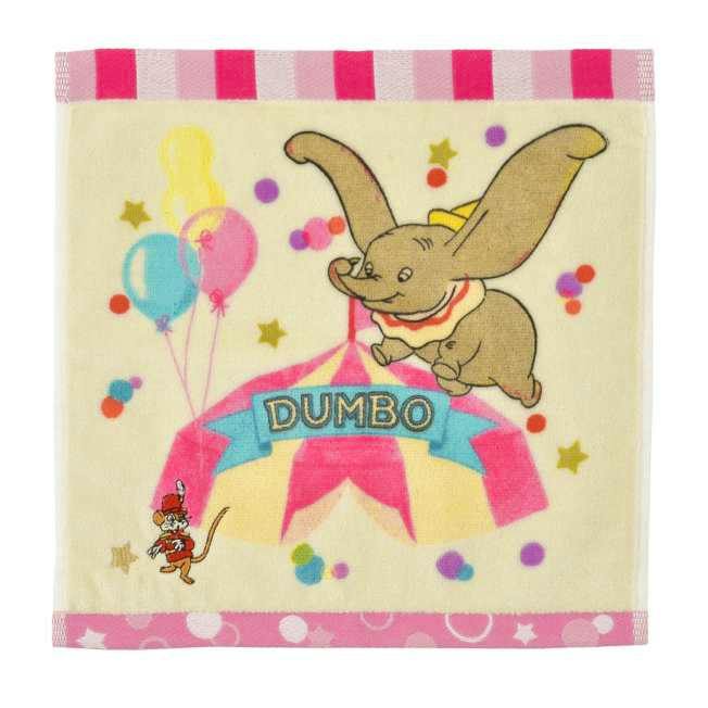 Square cream-colored mini cotton towel printed with Dumbo and Timothy, a circus tent, balloons, and the word "DUMBO".