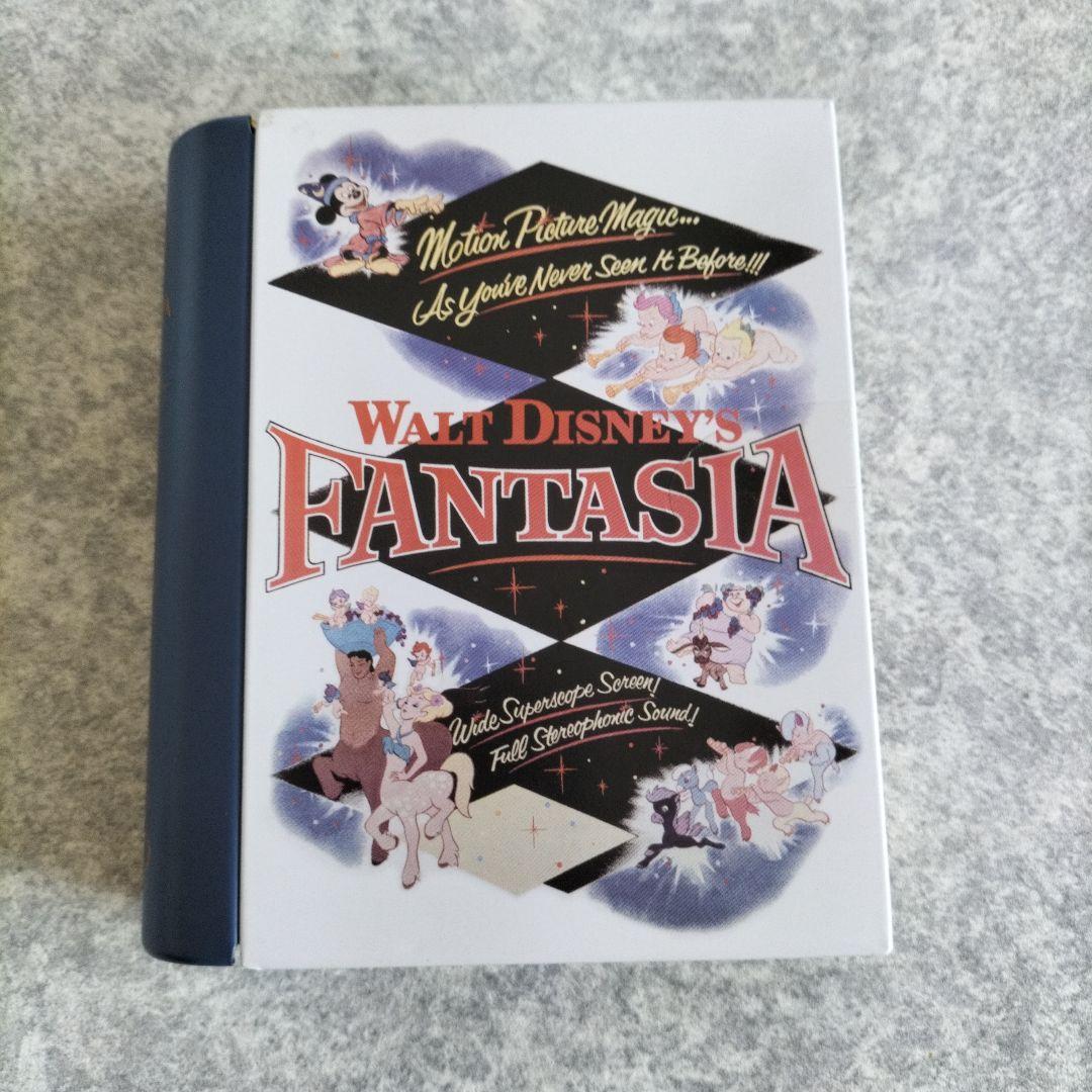 Front view of the book-shaped Godiva Disney Fantasia chocolate tin showing Fantasia cover artwork.