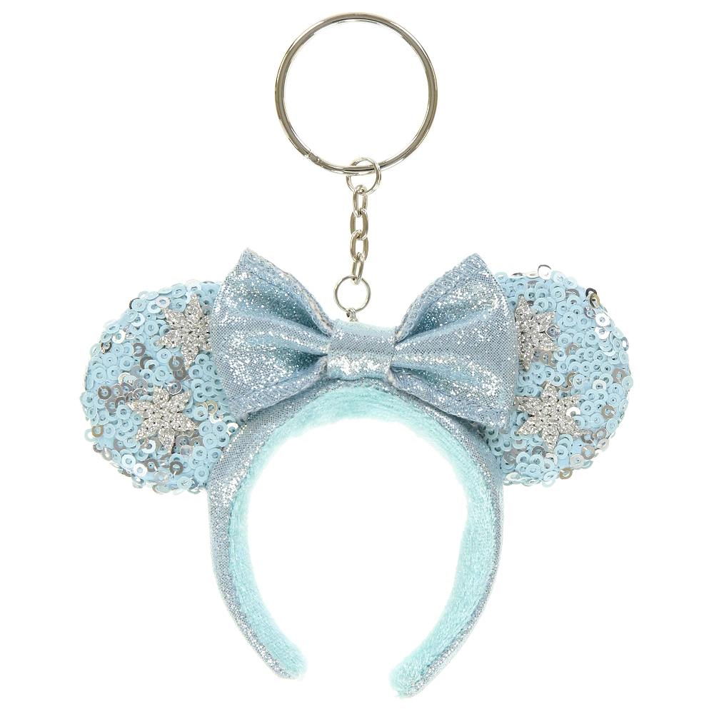 Light-blue fabric keychain shaped like a sequined ear headband with a glitter bow and attached metal key ring.