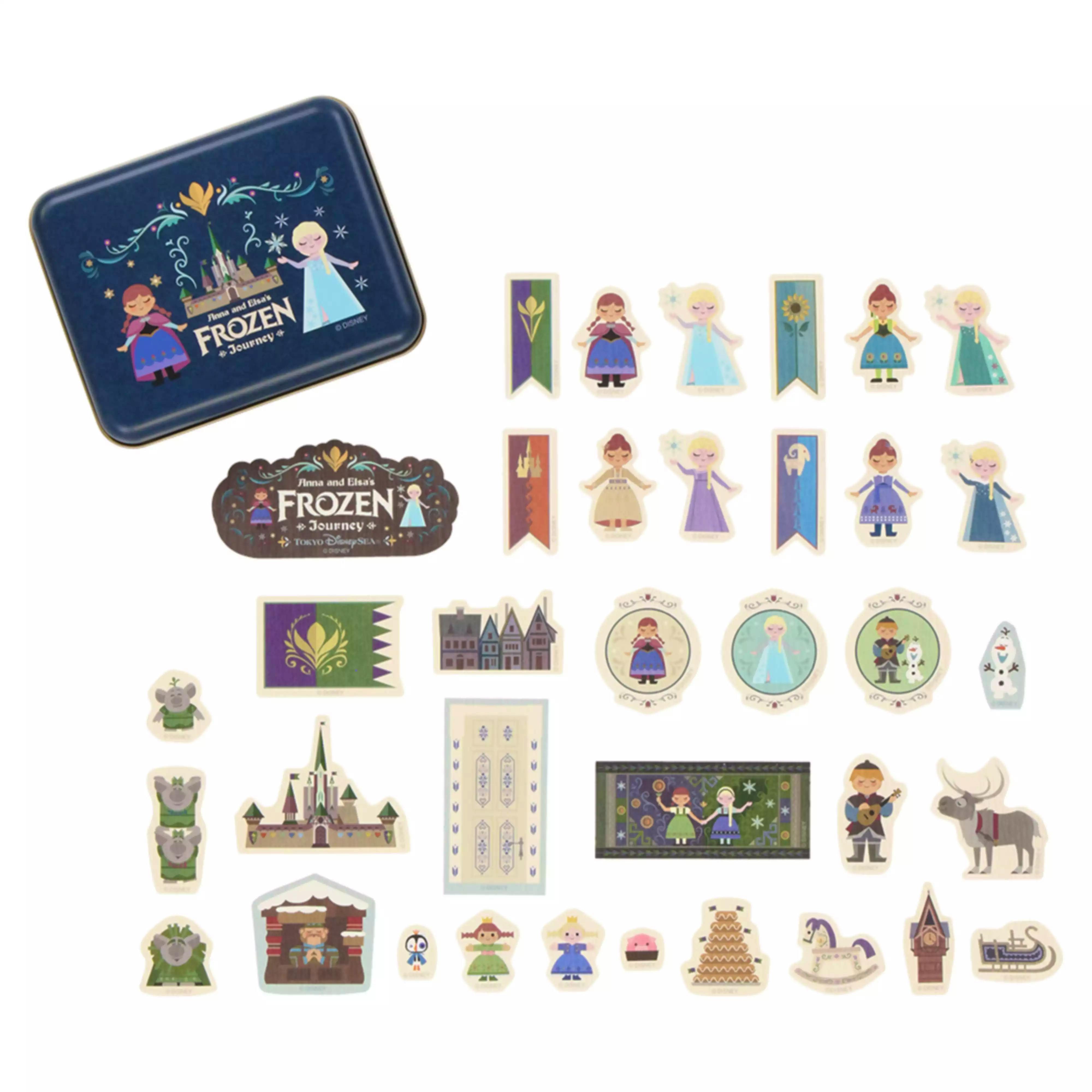 Blue metal tin alongside sheets of paper stickers showing Frozen characters and decorative icons.