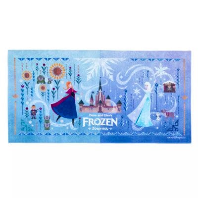 A blue wide polyester bath towel printed with Anna and Elsa, a castle, and the "Frozen" logo.