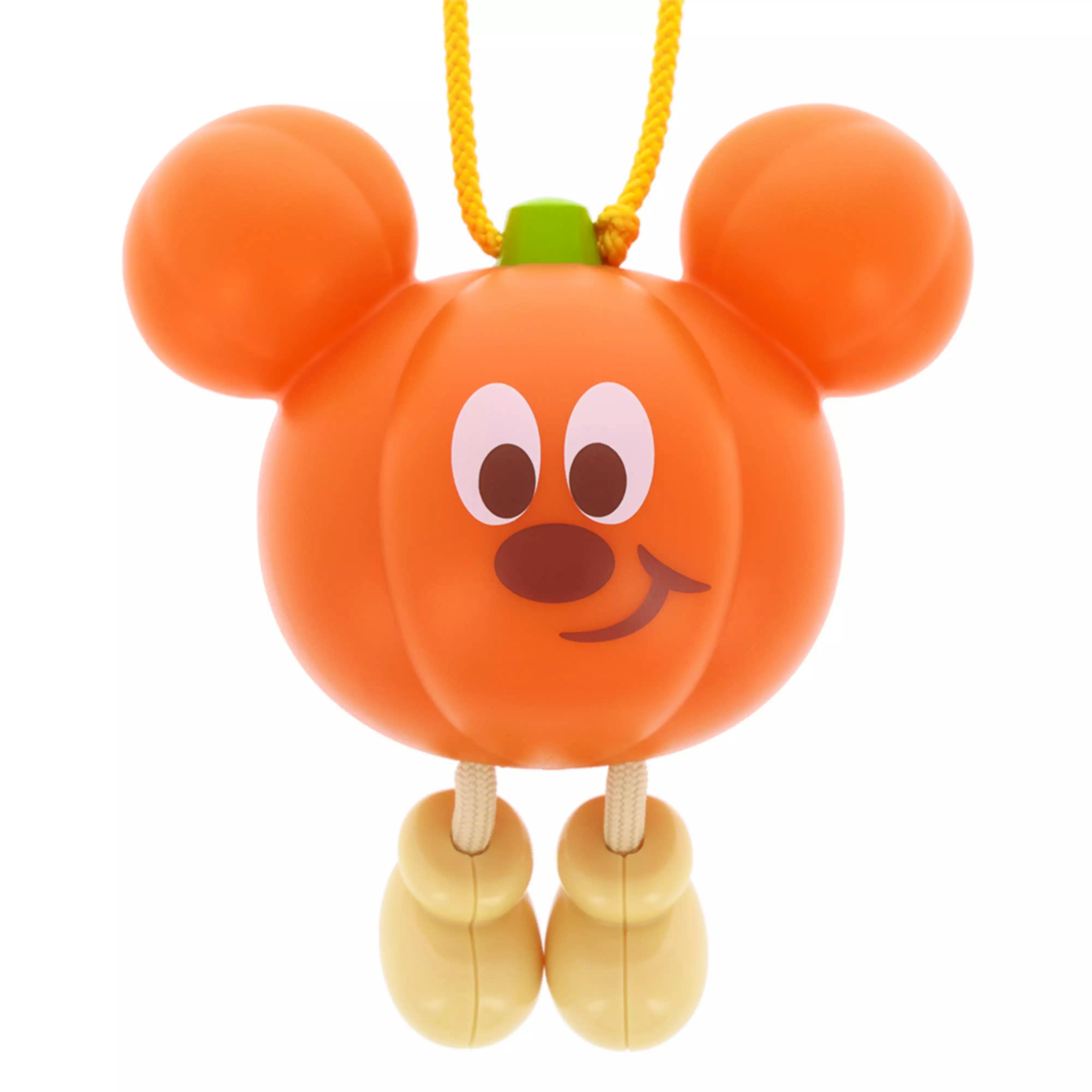 Close-up of the Disney Halloween glowing toy shaped like an orange pumpkin with Mickey ears, a yellow hanging cord, and bead legs.