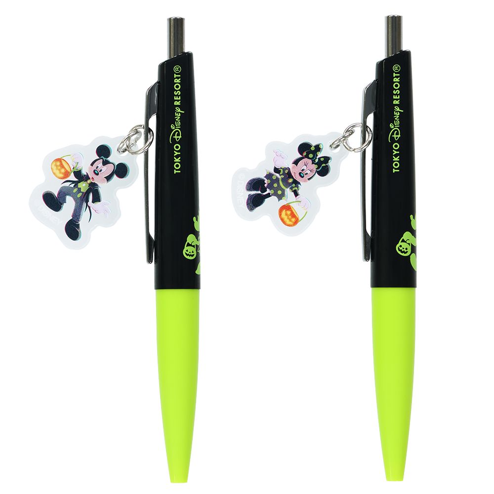 Two ballpoint pens with black upper and neon green lower barrels, each fitted with a Mickey or Minnie Halloween character charm and 'TOKYO Disney RESORT' text on the barrel.