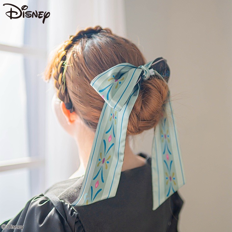 A polyester multi ribbon with a printed pattern tied as a bow on the back of a model's hair.