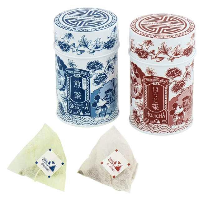 Two decorative tea tins with Mickey and Minnie illustrations shown alongside two pyramid tea bags.