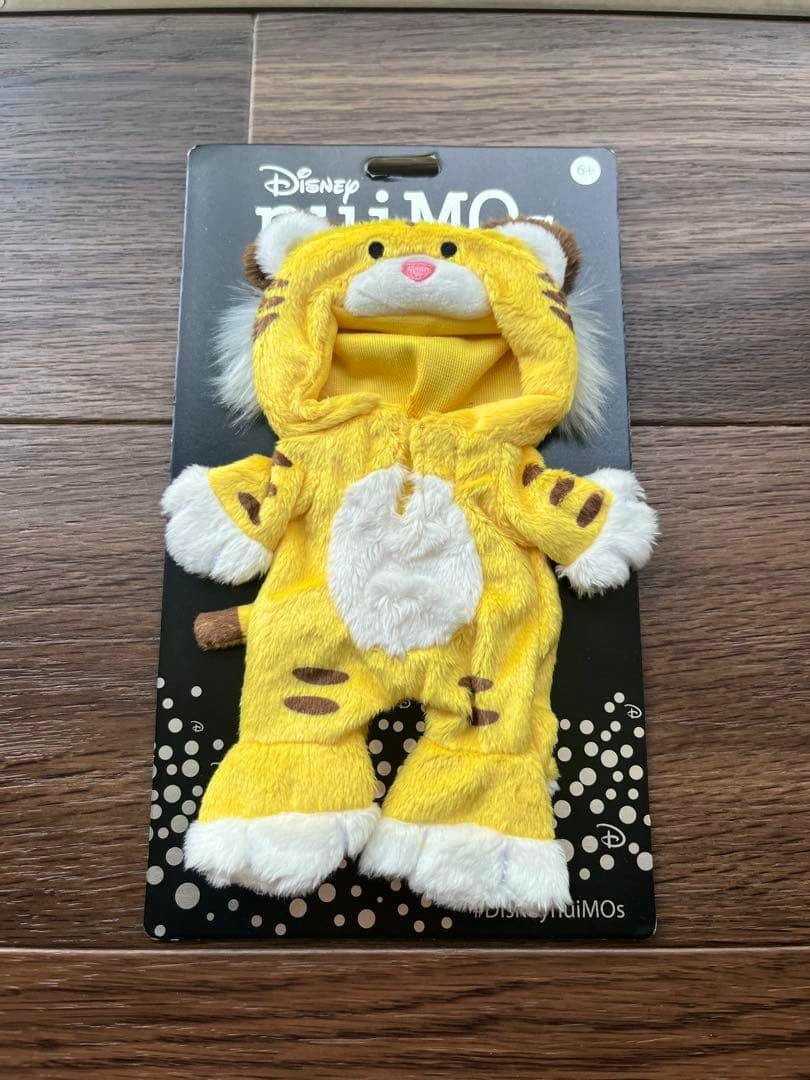 Front view of a yellow tiger costume for Disney nuiMOs dolls displayed on a black backing card.