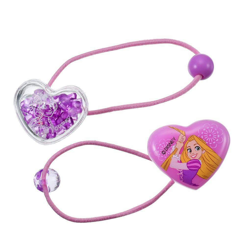 Two pink elastic hair bands with heart-shaped Rapunzel-themed decorations, one clear heart filled with purple beads and one solid heart printed with Rapunzel.