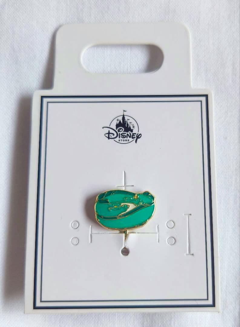 Front of a Disney Store earring card displaying a green Flotsam/Jetsam earring.