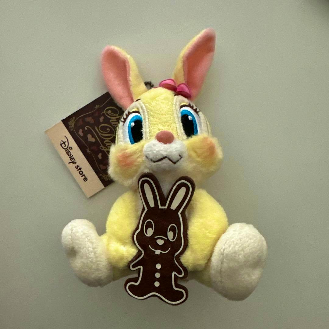 Front view of the Disney Miss Bunny plush keyholder showing the yellow bunny with blue eyes, pink inner ears, a brown bunny-shaped decoration, and an attached Disney Store tag.