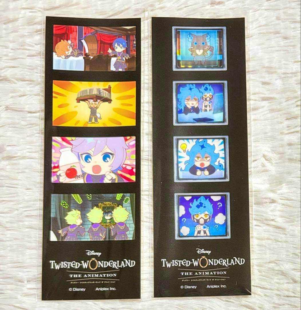 Photo of two Twisted-Wonderland four-panel paper sticker strips showing chibi character panels and Twisted-Wonderland branding on black backing.