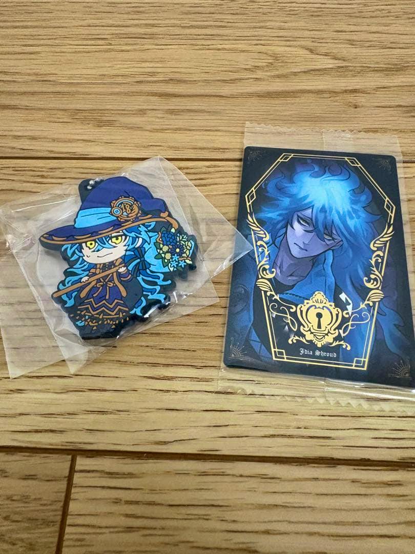 Sealed rubber keychain of the character Idea (イデア) shown next to a matching character card on a wooden surface.