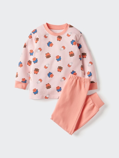 Pink children’s long-sleeve cotton pajama top with a small Winnie-the-Pooh pattern and matching coral pants laid flat on a white background.