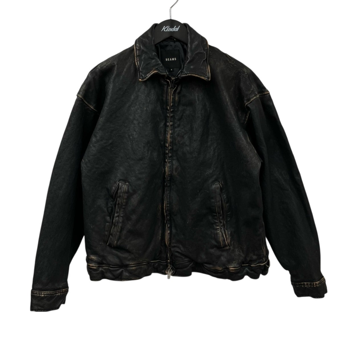 Front view of a distressed black cow leather zip-up blouson jacket hanging on a hanger.