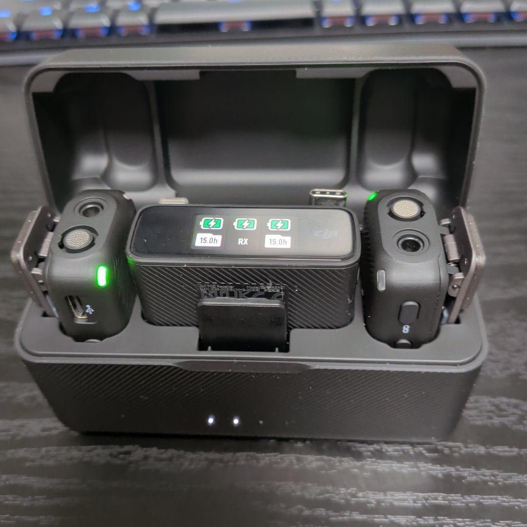 Open DJI charging case displaying two wireless microphone transmitters and a receiver inside.