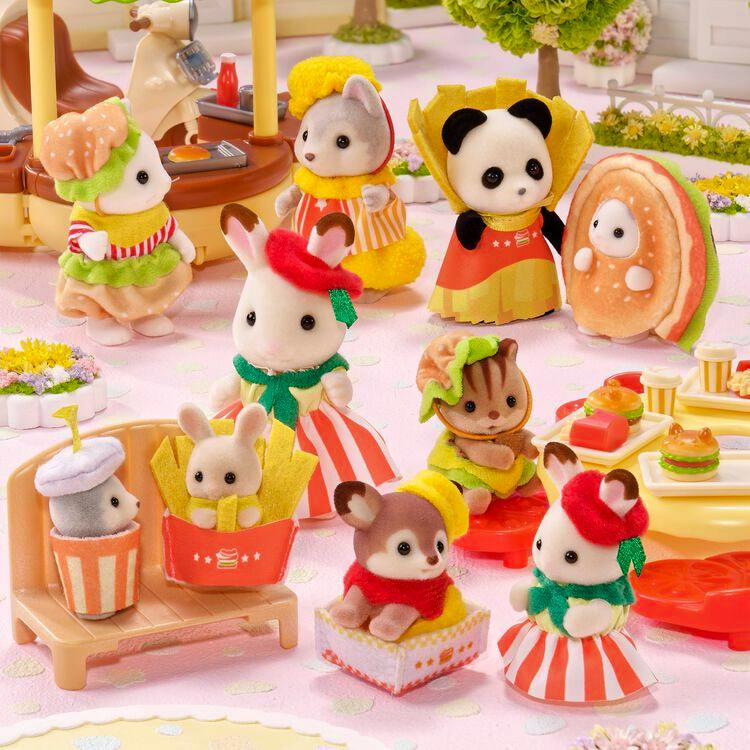 Several Sylvanian Families animal figures in hamburger-themed outfits arranged in a playset scene.