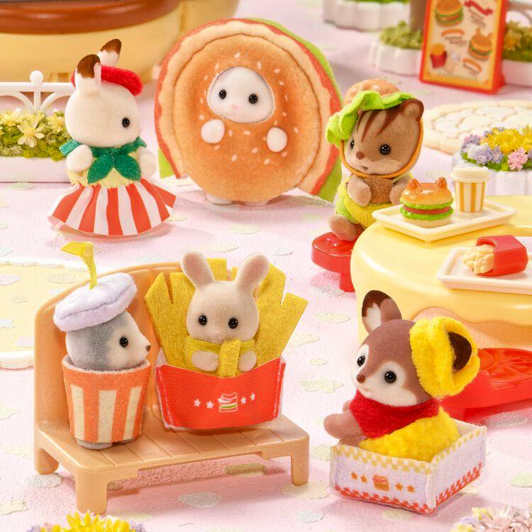 Sylvanian Families baby hamburger-shop figure parts and accessories posed in a play scene, including a burger costume, fries box, and drink cup.