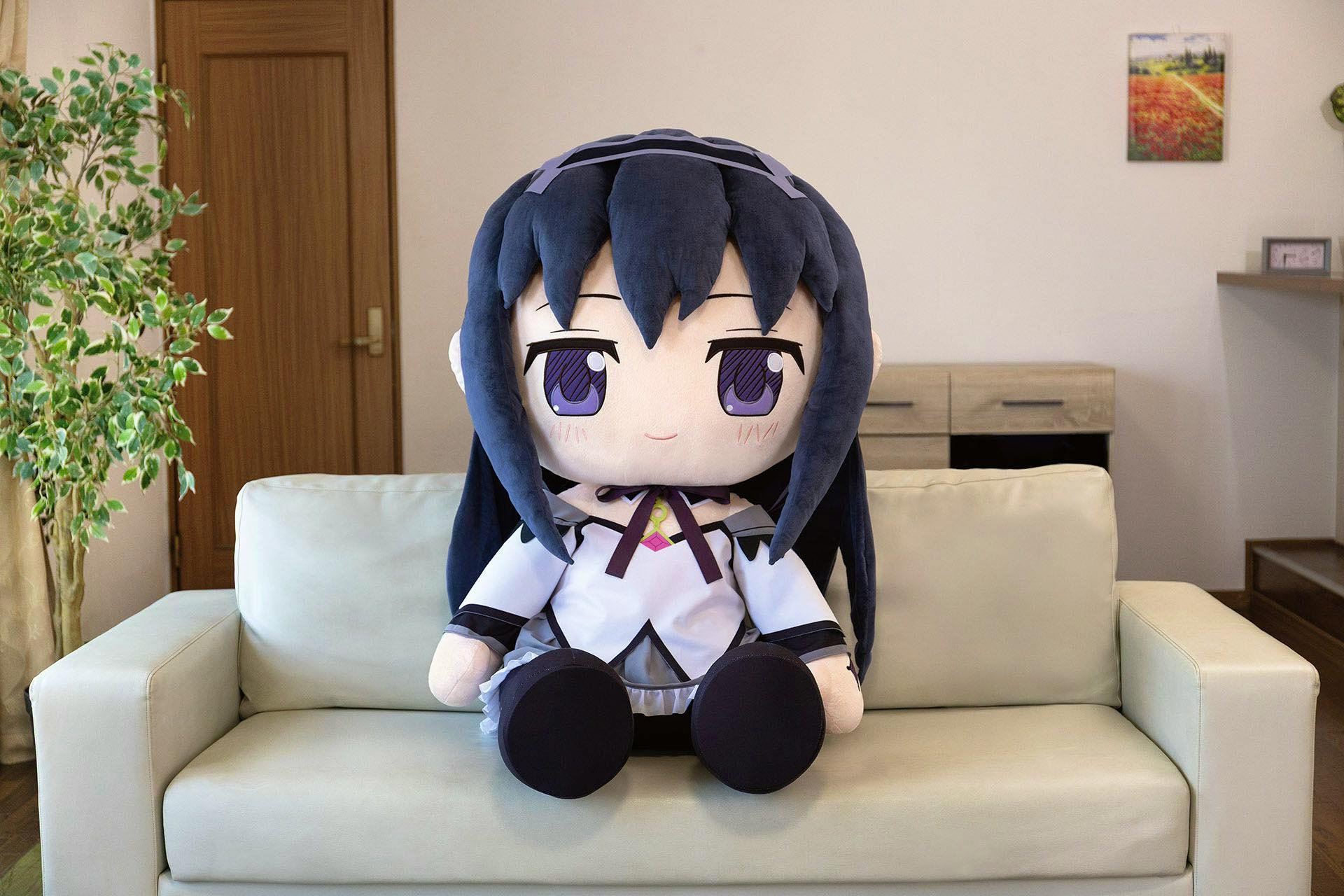 Front view of the oversized Akemi Homura plush sitting on a light-colored sofa.