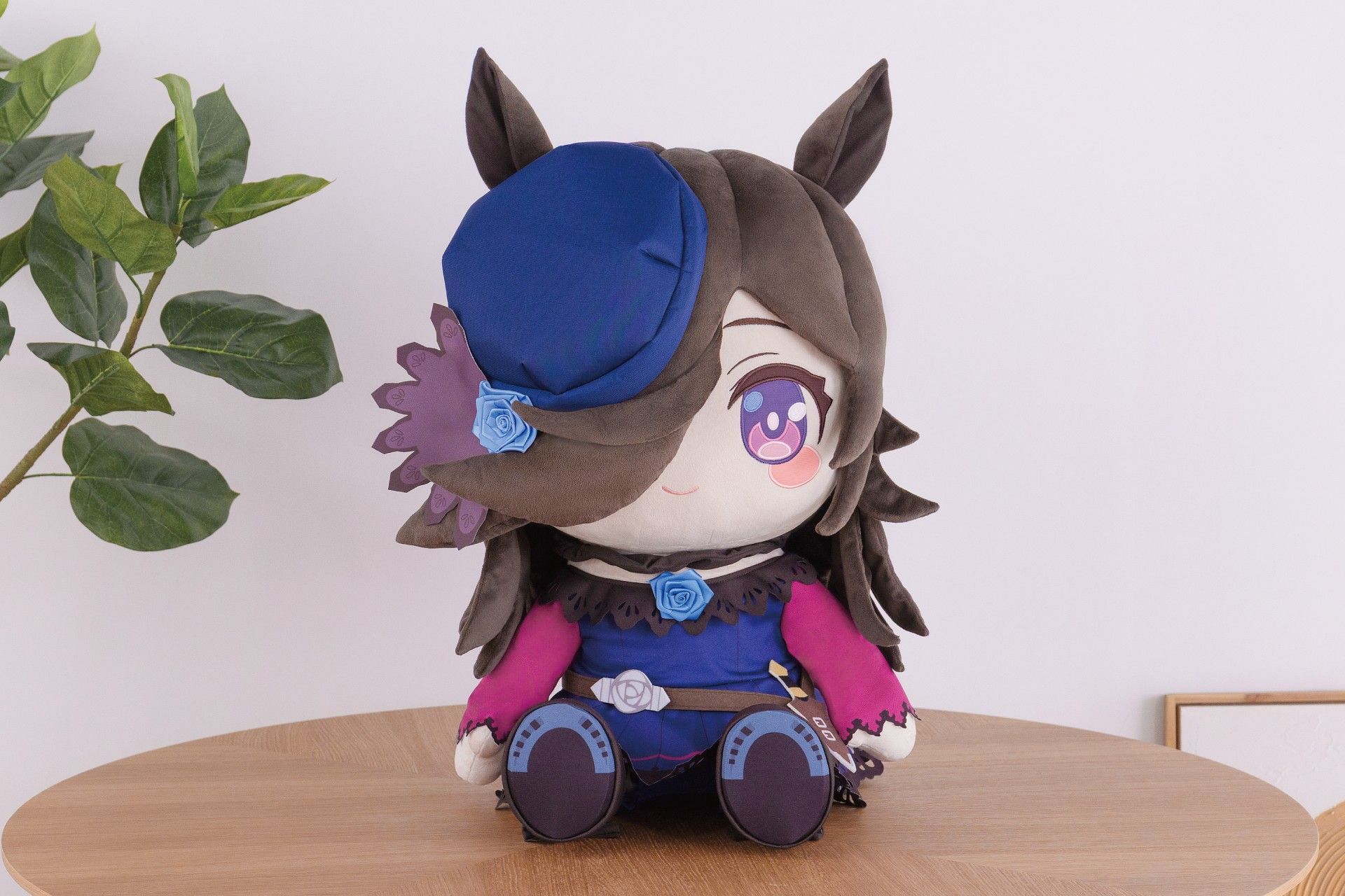 Front view of the Rice Shower plush (ウマ娘 プリティーダービー) seated on a wooden table.