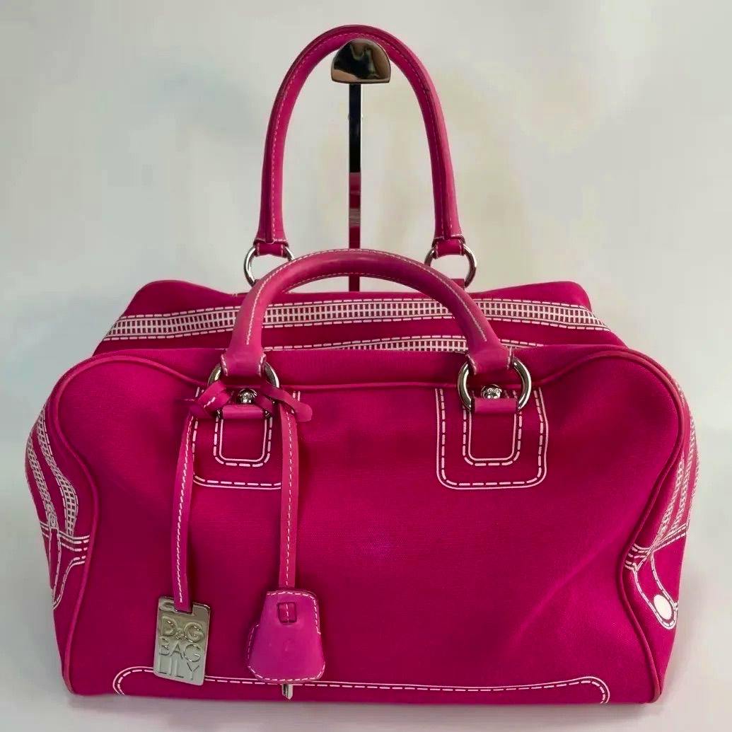 Front view of a large fuchsia Dolce&Gabbana (Lily Ghost) handbag with handles and a hanging lock tag.