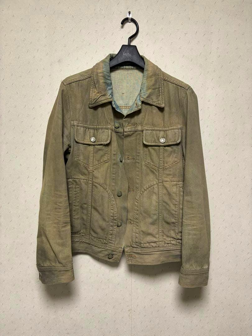 Front view of the men's cotton jacket on a hanger showing button front, two chest flap pockets, and a worn/distressed finish.