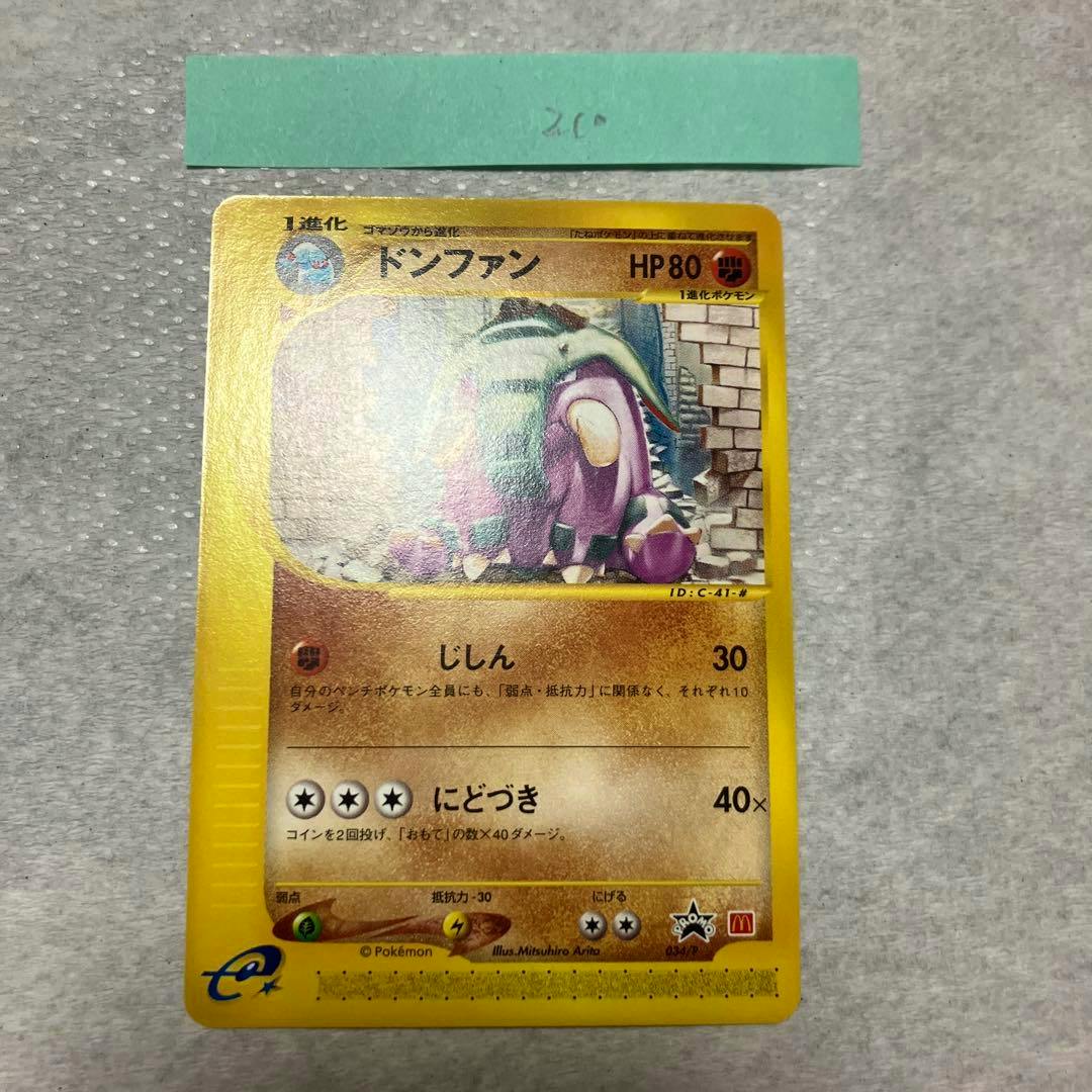 Photograph of the front of the Donphan promotional trading card (Japanese text) showing the artwork, HP80, moves and McDonald’s promo mark on a grey textured background.