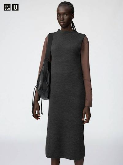 Model wearing a dark gray double-face knit midi dress over a brown long-sleeve top while carrying a black shoulder bag.