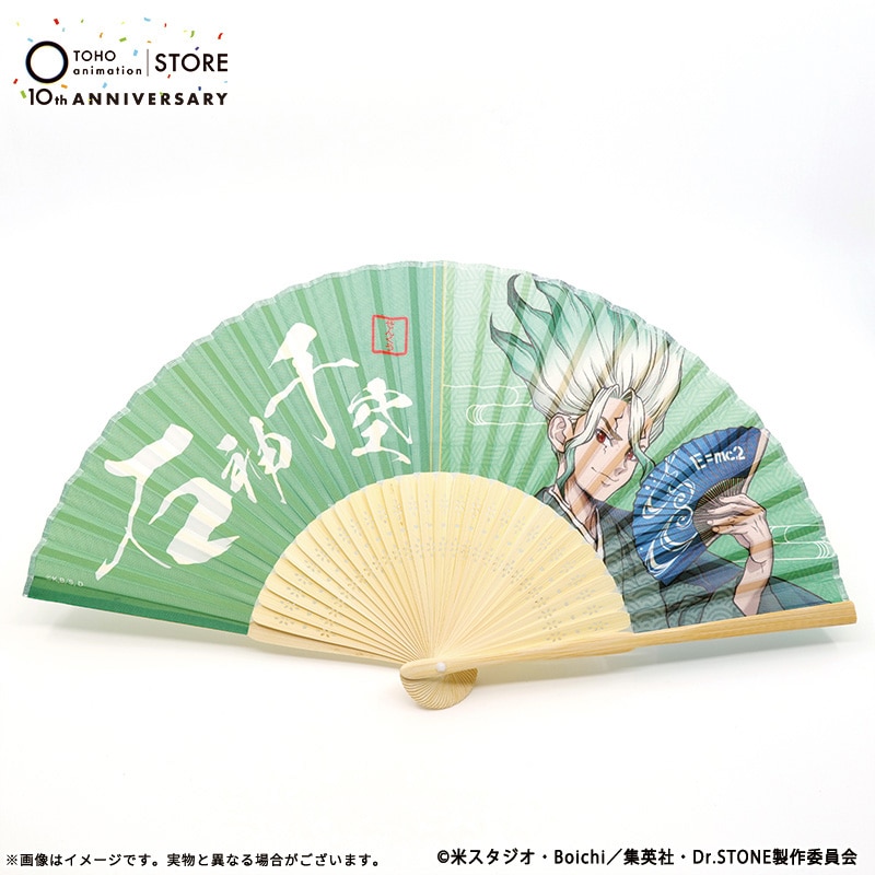 Photo of a green paper folding fan printed with Dr.STONE character 石神千空 and white calligraphy.