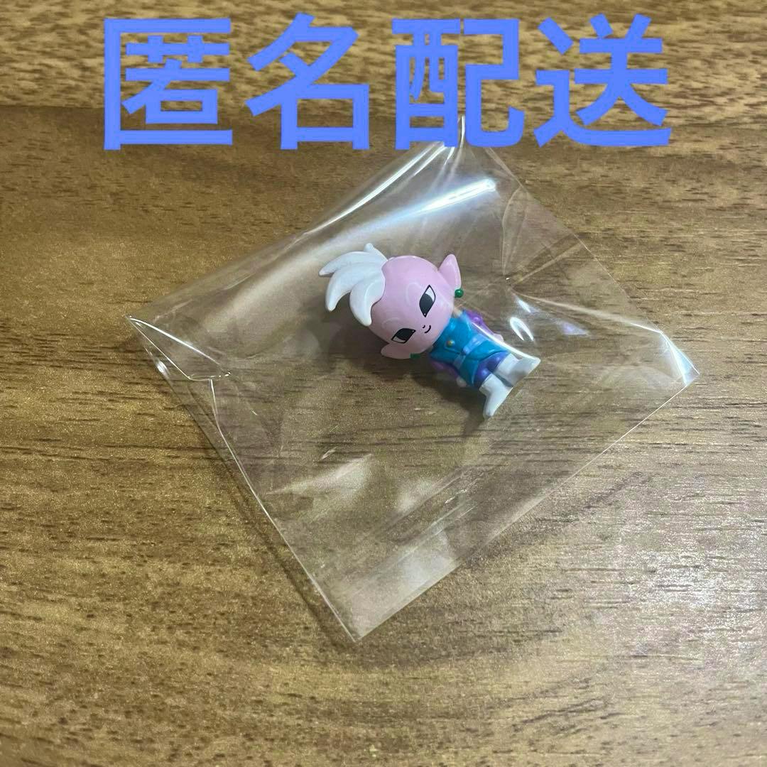 Plastic Dragon Ball Kaio-shin figure sealed in a clear plastic bag on a wooden surface.