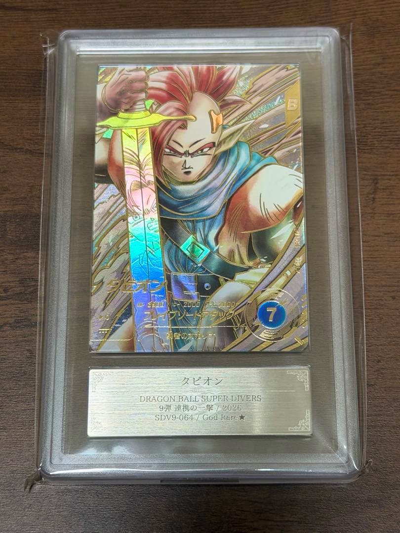 Close-up of the Dragon Ball Super Divers SDV9-064 (Tapion) trading card in a clear protective slab showing the holographic card artwork and the nameplate.