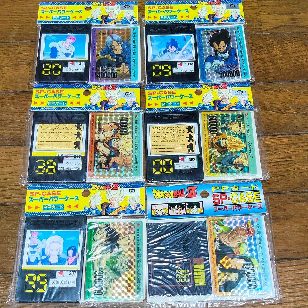 Six unopened Dragon Ball Z PR card SP-CASE super power cases in their original packaging arranged on a wooden surface.