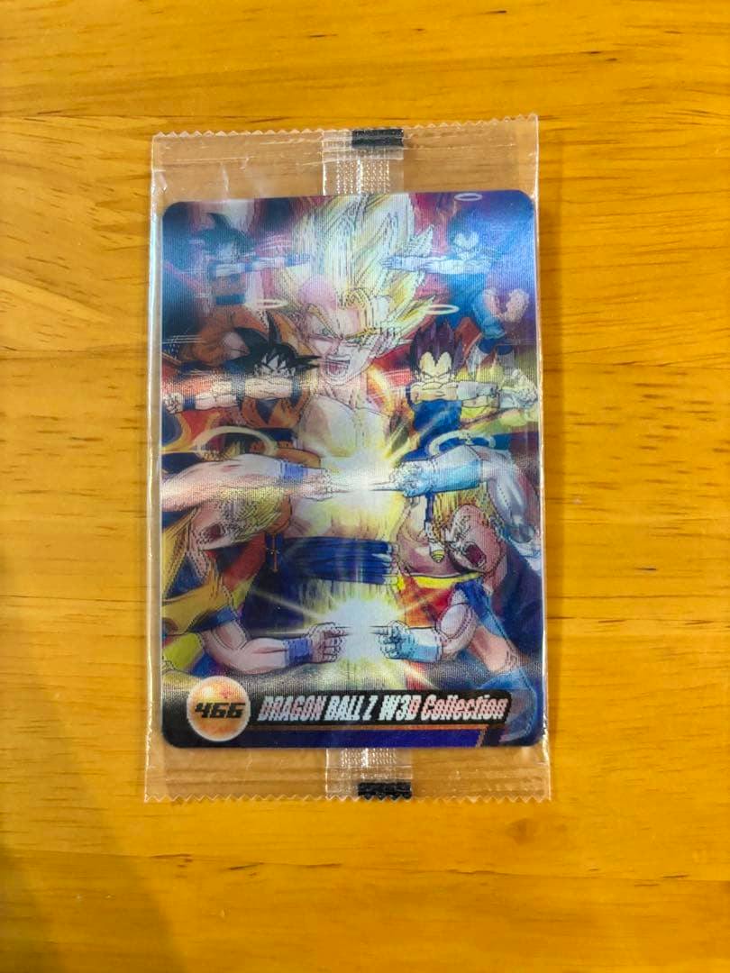 Sealed 森永ウエハース ドラゴンボールZ W3D Collection 466 photocard in a clear plastic wrapper on a wooden surface.