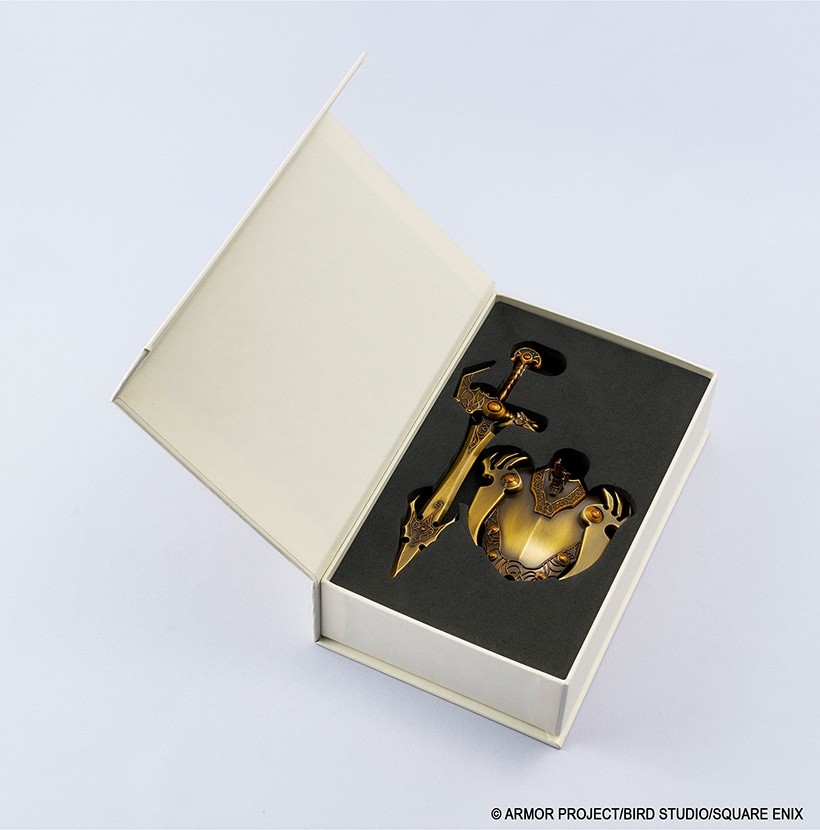 Open presentation box containing the metal sword and shield toy set seated in a black foam insert.
