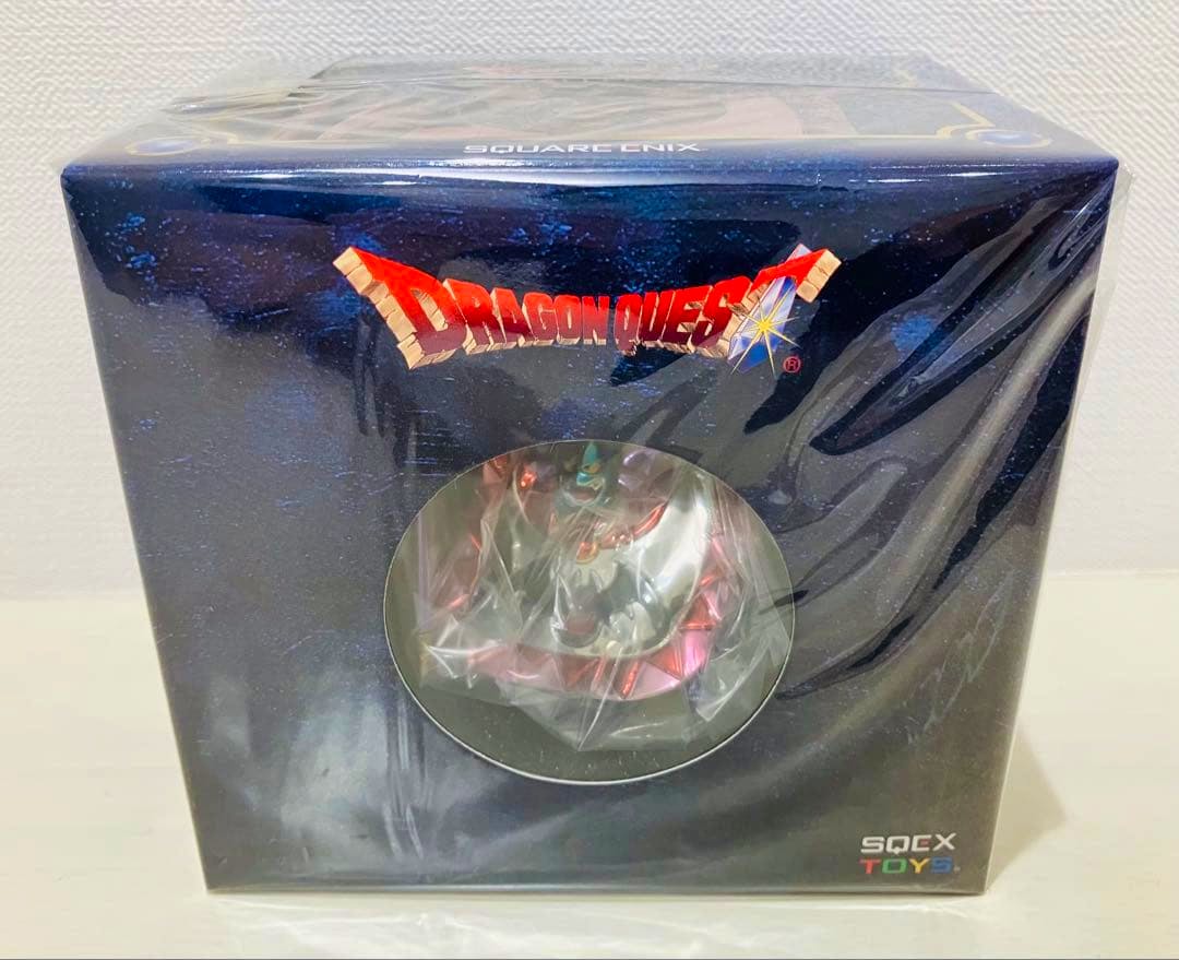 Front view of the boxed Dragon Quest Metallic Monsters Gallery ハーゴン figure in sealed retail packaging with a round display window showing the figure.