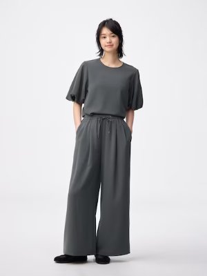 Model wearing the drape wide women's pants in gray, standing against a plain white background.