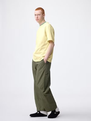 A model wearing the women's pants in olive green, shown full-length in profile against a white background.