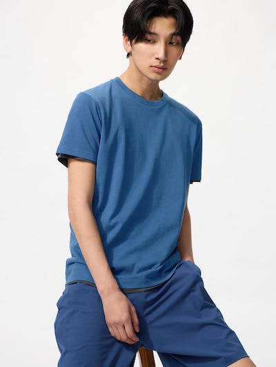 A male model wearing a blue crew-neck T-shirt against a white background.