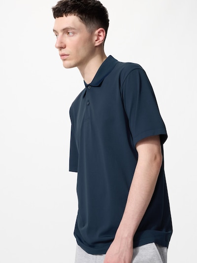 A male model wearing a dark blue short-sleeve polo shirt shown in a three-quarter side view.
