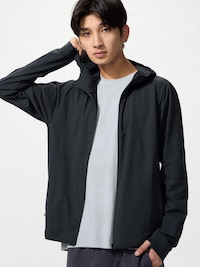 Male model wearing a black full-zip hooded men's polyester jacket over a light T-shirt.