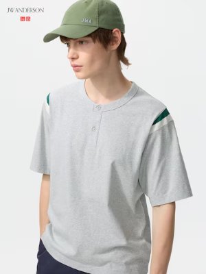 Male model wearing a light grey henley-neck short-sleeve men's T-shirt with green shoulder stripes.