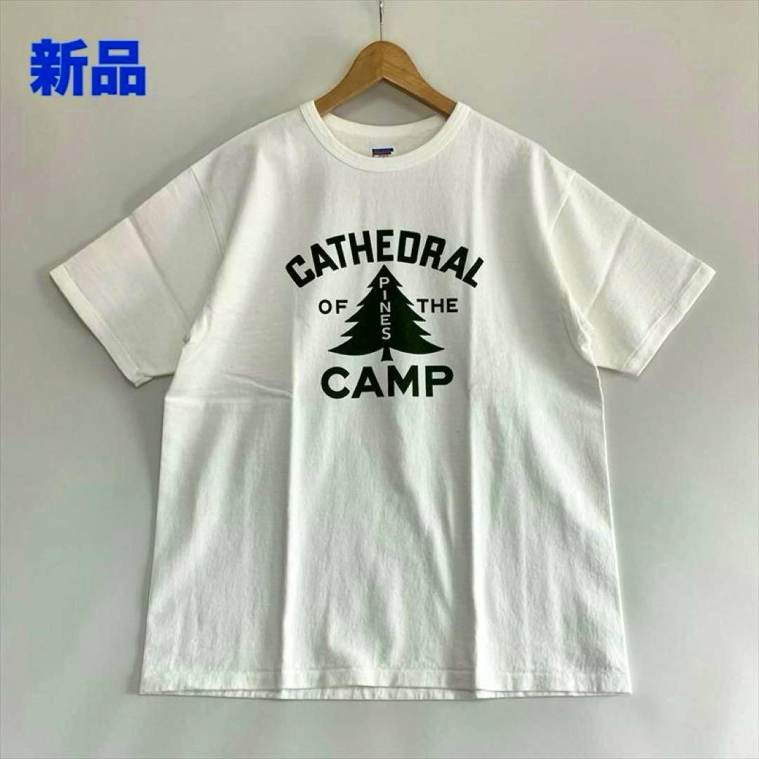 Off-white Dubble Works printed cotton T-shirt hanging on a wooden hanger showing a black tree graphic and the words "CATHEDRAL" and "CAMP" on the front.