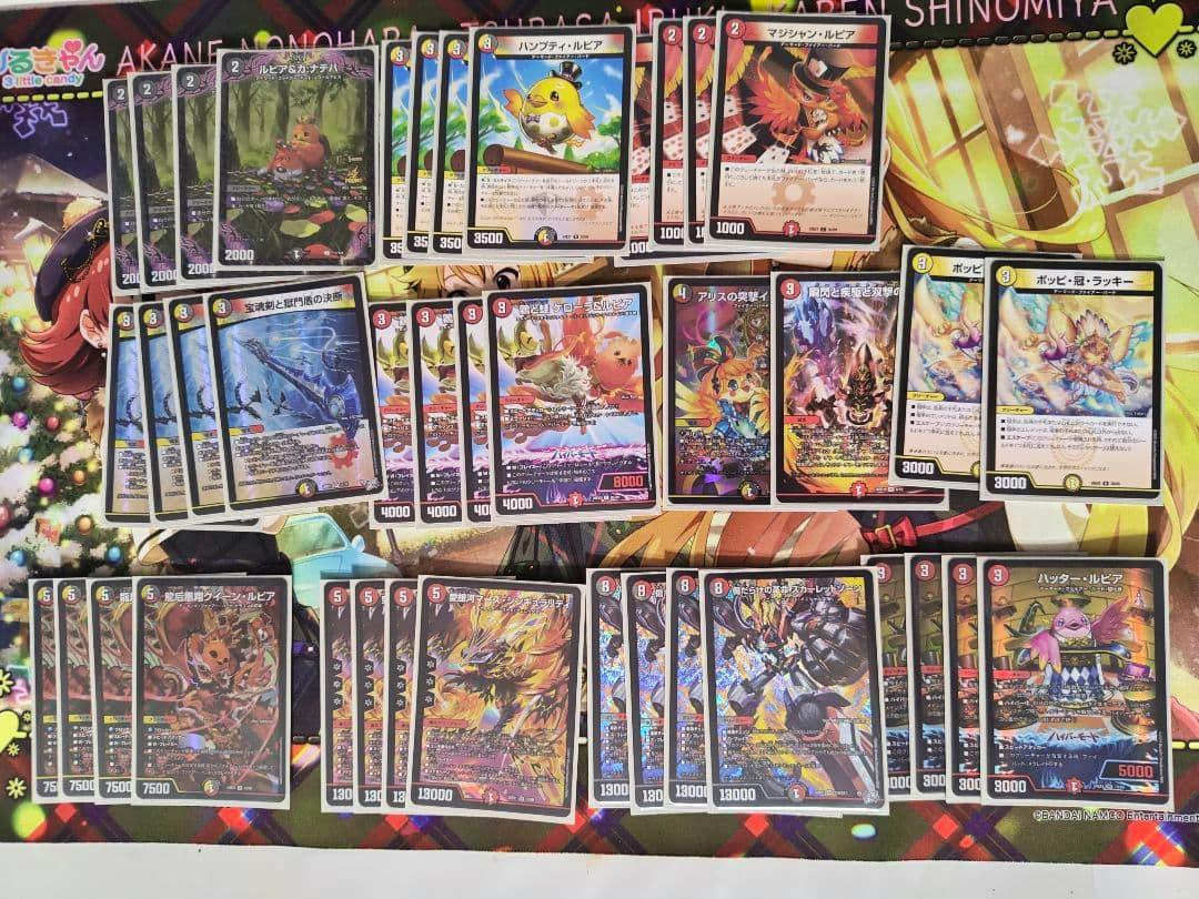 Photo of a Duel Masters trading card deck showing many cards neatly arranged on a playmat.