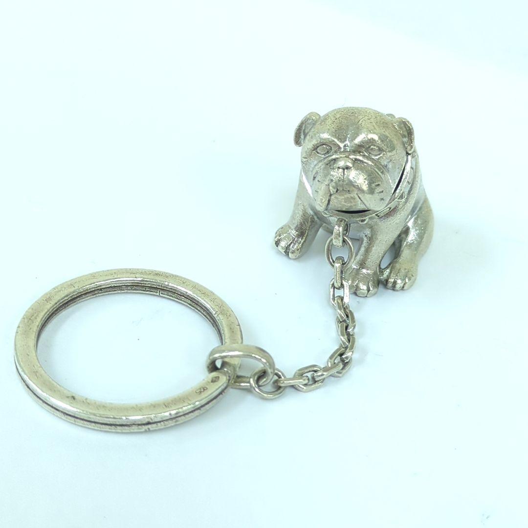 Silver bulldog keychain with a short chain and attached split key ring on a white background.