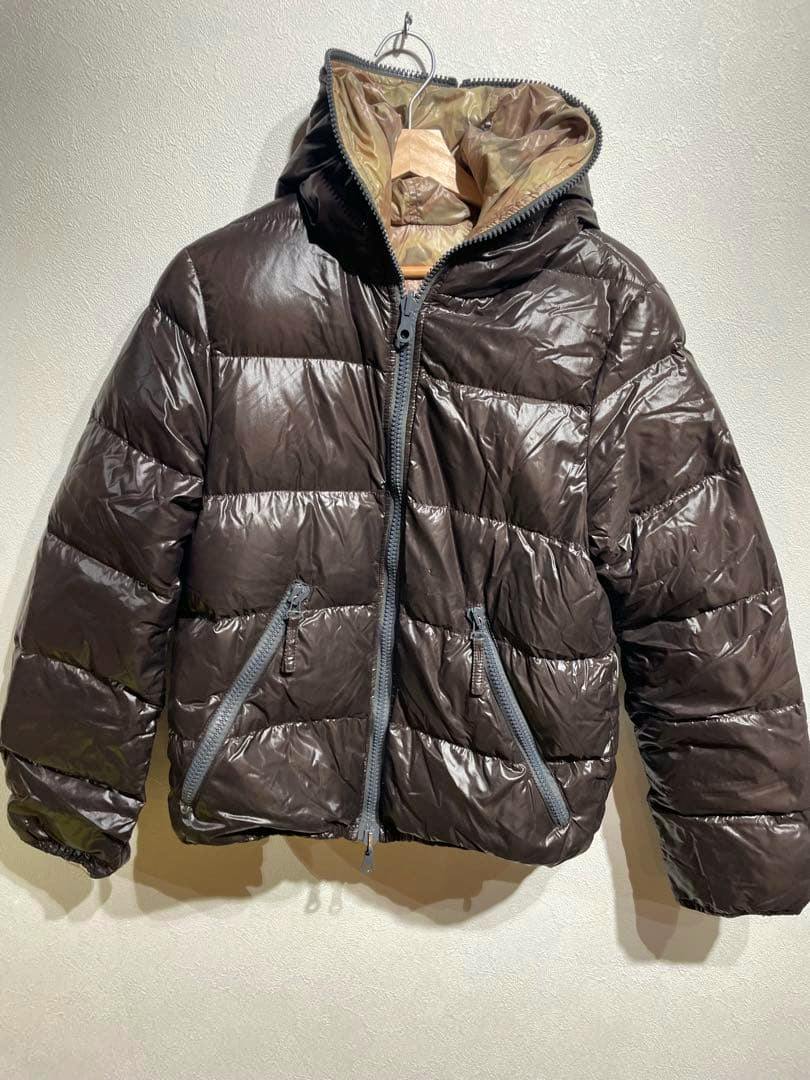 Brown DUVETICA hooded glossy down jacket hanging on a hanger against a light wall.