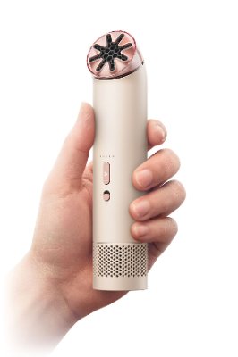 A hand holding the Dyson HushJet Mini Cool handy fan showing the full device and controls.