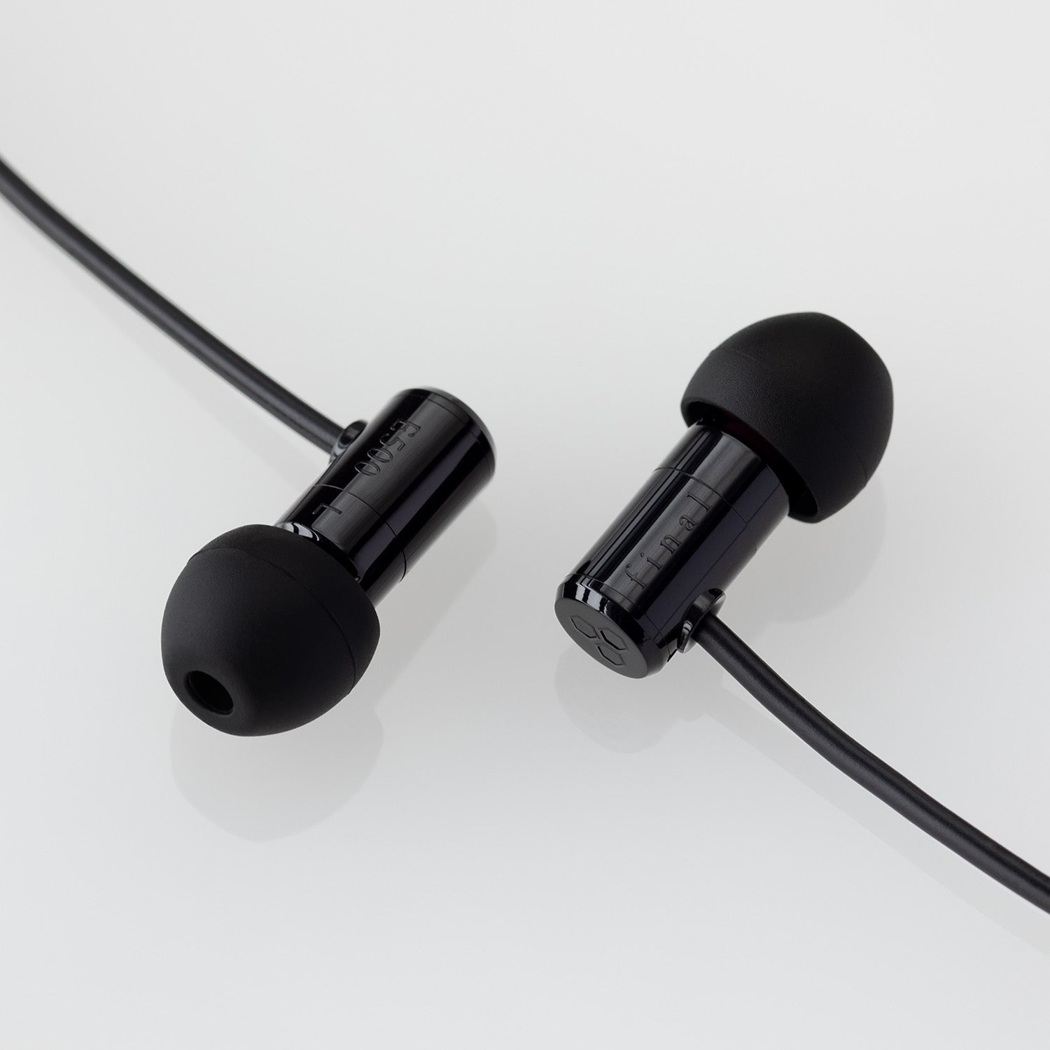 Pair of black in-ear earphones with black silicone tips and attached cable on a white background.