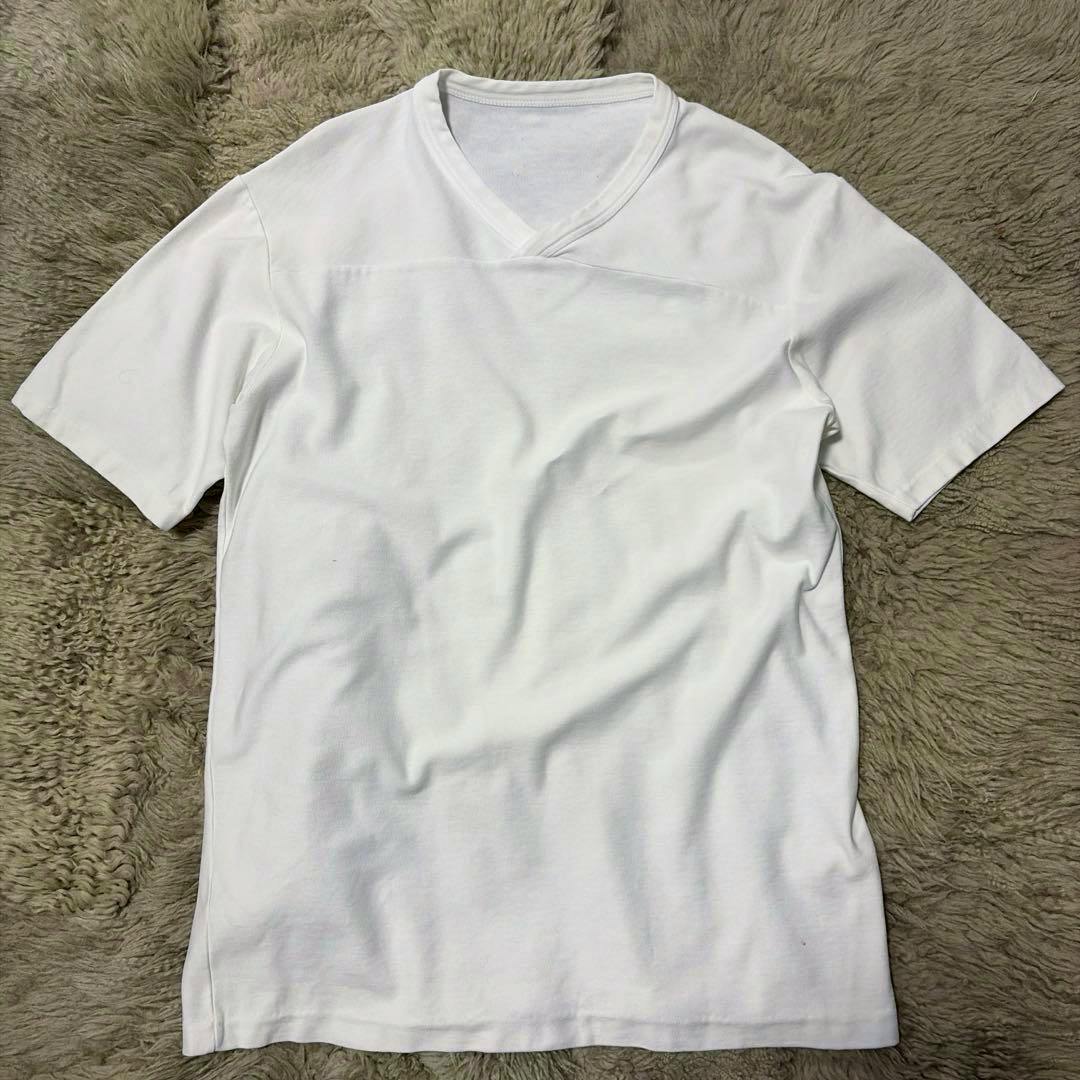 Front view of the Maison Martin Margiela cotton football T-shirt laid flat on a textured fur rug.