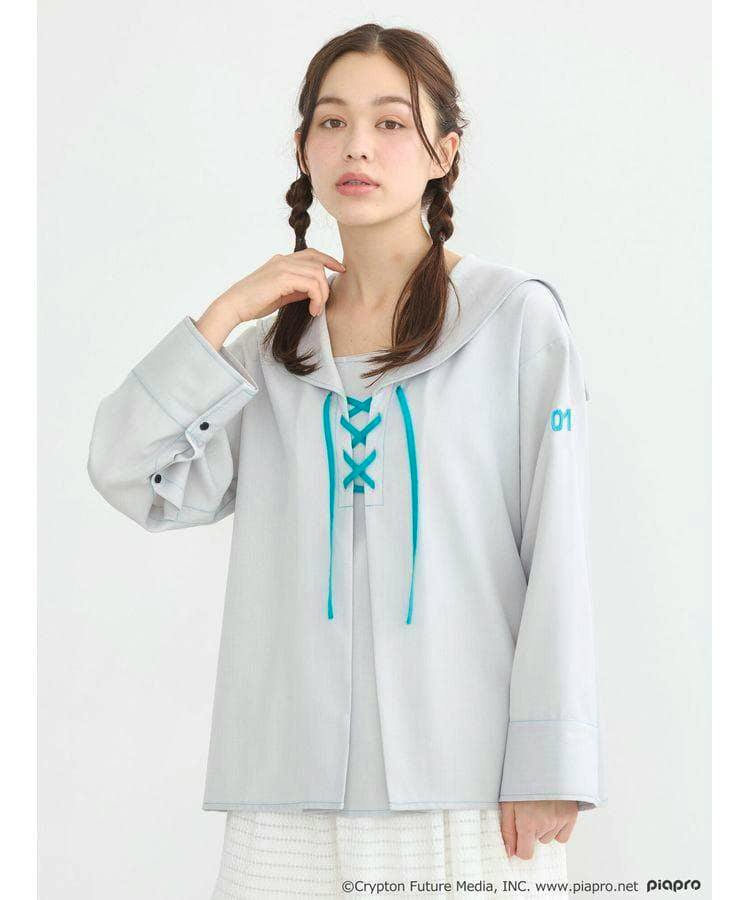 Woman modeling a light gray sailor-style long-sleeve shirt with teal lace-up front and a small "01" on the sleeve.
