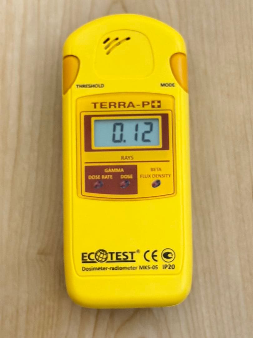 Front view of a yellow ECOTEST TERRA-P+ MKS-05 radiation detector showing a digital display reading 0.12.