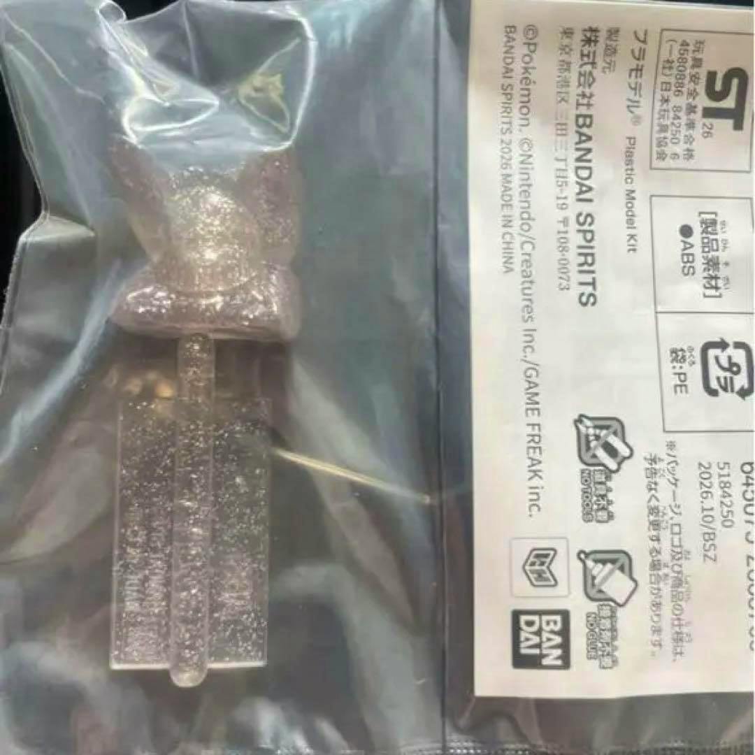 Clear glittery plastic Eevee figure in its sealed bag alongside a Bandai Spirits instruction sheet.